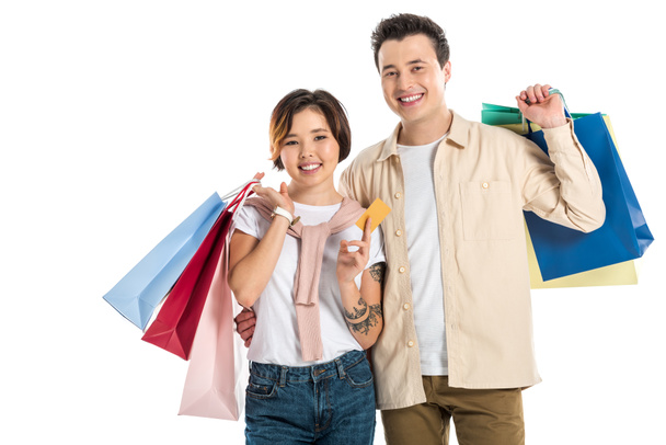 boldog pár bevásárló táskák és elszigetelt fehér hitelkártya  - Fotó, kép