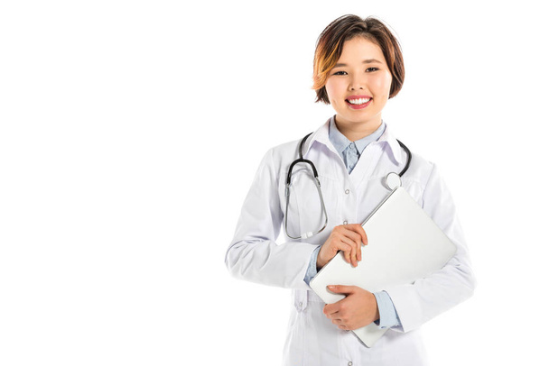 smiling female doctor looking at camera and holding diagnosis isolated on white - Photo, Image