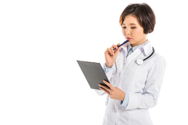 médico feminino pensivo segurando diagnóstico e caneta isolada em branco
 - Foto, Imagem
