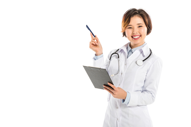 smiling female doctor holding diagnosis and pen isolated on white - Foto, Imagem