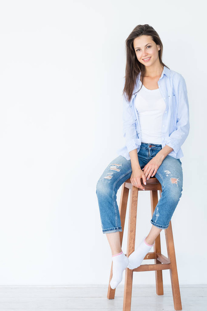 smiling woman sit stool white background casual - 写真・画像