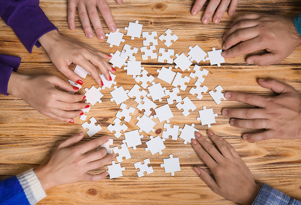 Group of people doing puzzle on table - Foto, Imagem