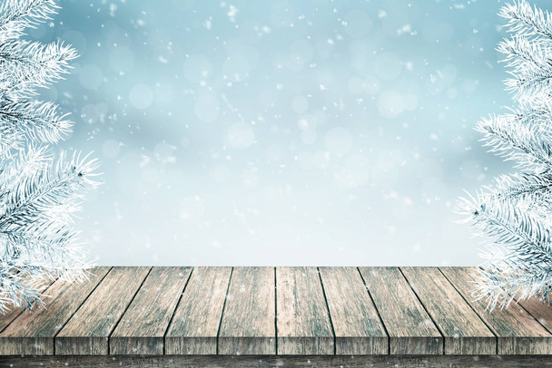 空の木製テーブルとクリスマスのモミの木は、雪で覆われています。雪が降る。青色の背景. - 写真・画像