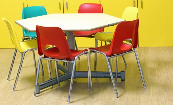 sillas de colores pequeños de un aula de jardín de infantes sin niños con piso de madera
 - Foto, imagen
