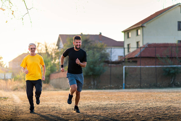 Senior father and son running in the park - Photo, Image