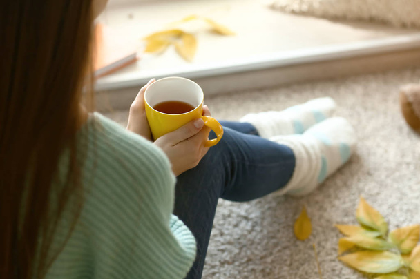 Woman drinking tea while resting at home on autumn day - Foto, Imagem