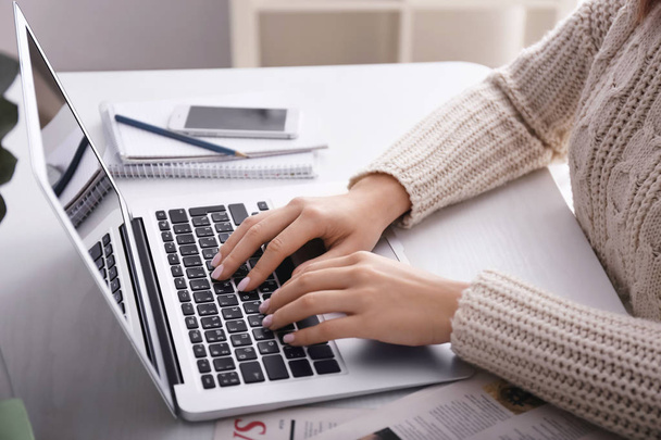 Жінка використовує ноутбук на світлому столі, крупним планом
 - Фото, зображення