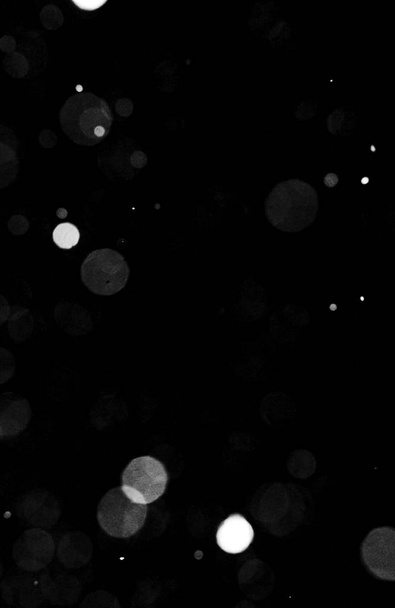 Textura tormenta de nieve. Luces Bokeh sobre fondo negro, plano de copos de nieve voladores en el aire
 - Foto, Imagen