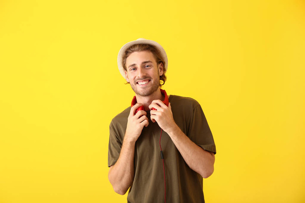 Young man with headphones on color background - Photo, Image