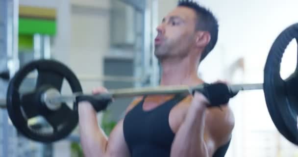 Guy bodybuilder in the gym, works with a barbell, bench press, improving triceps, large pectorals muscle, anterior deltoids muscle Concept love sports, go to the gym, eat right, slim body, be healthy. - Video, Çekim