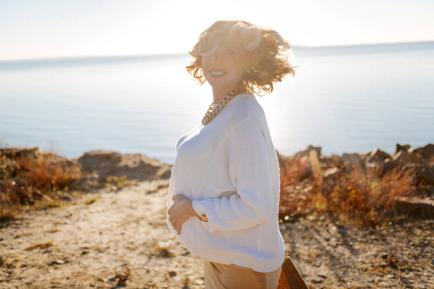Cheerful pregnant woman spending sunny day outdoor - Foto, Imagen