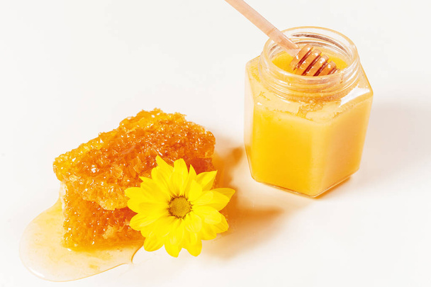 jar of honey and stick isolated on white background - 写真・画像