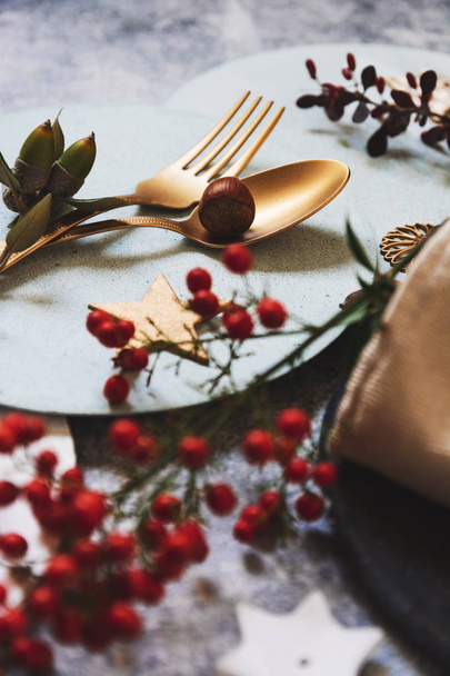 クリスマスのテーブルセッティング、黄金刃物、nandinas、グランジのテーブルの上。ホリデイ ・歓迎 - 写真・画像