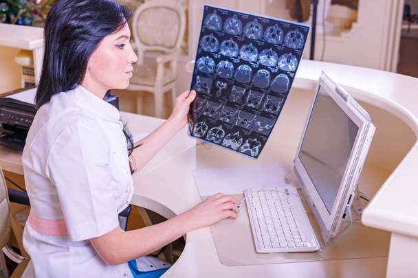 Γιατρός θηλυκό κοιτάζοντας μια εικόνα ακτινογραφία τομογραφία - Φωτογραφία, εικόνα