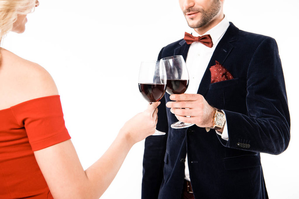Částečný pohled pár cinkání sklenic s červeným vínem, izolované na bílém - Fotografie, Obrázek