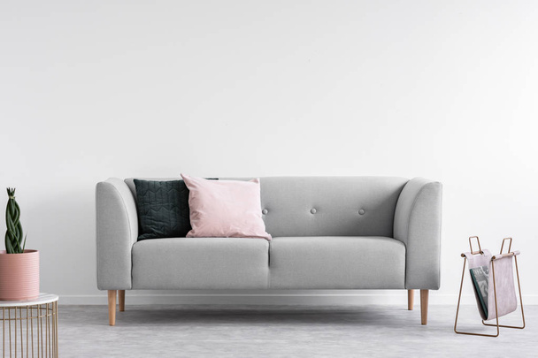 Scandinavian minimal design with grey comfortable sofa, real photo with copy space on the wall - Zdjęcie, obraz