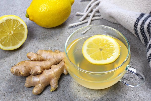 Ginger tea with lemon slice and glass cup. Healthy tea time with fresh ginger root. Winter scene, top view. - Fotografie, Obrázek