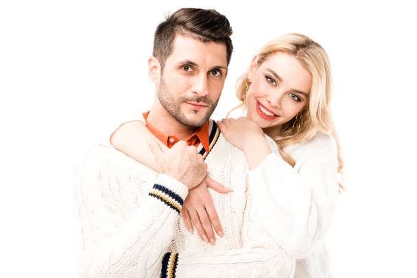 Attractive couple looking at camera while hugging and holding hands isolated on white - Fotoğraf, Görsel