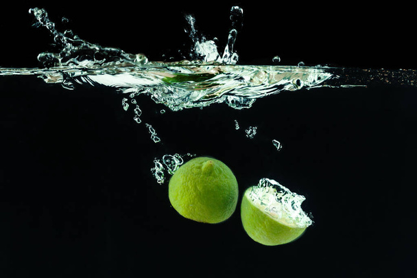 Fresh lime dropped into water with splash - Foto, Imagen