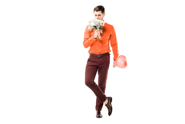 schöner Mann, der Blumenstrauß riecht, während er rote Luftballons isoliert auf weiß hält - Foto, Bild