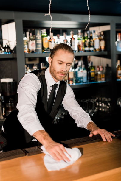 Bello barman pulizia bancone bar in legno con tovagliolo bianco
  - Foto, immagini