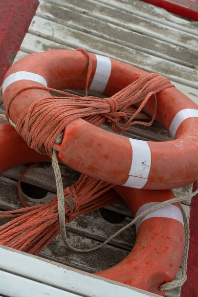 Boyas salvavidas naranja con cuerdas en un catamarán de remo de rescate
 - Foto, Imagen