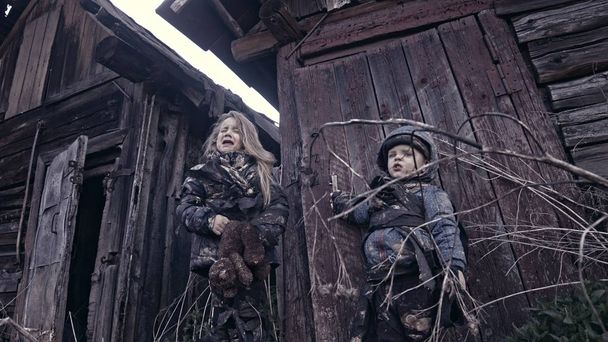 portrait of little dirty homeless kids with bear toy crying against abandoned building - Fotoğraf, Görsel