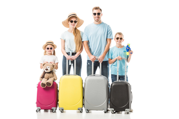 Happy family standing with colourful luggage and smiling isolated on white - Photo, Image