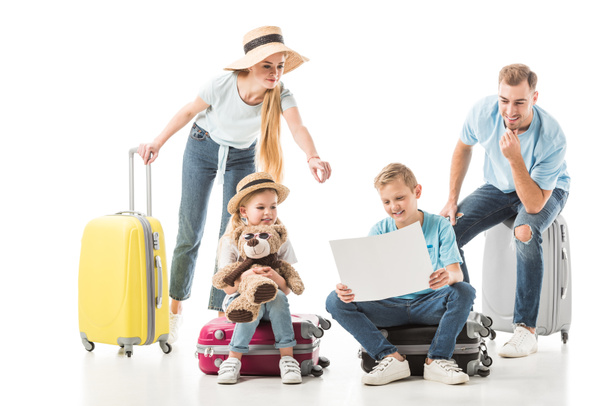 Mother pointing at map and kids with dad sitting on luggage isolated on white - Foto, Imagem