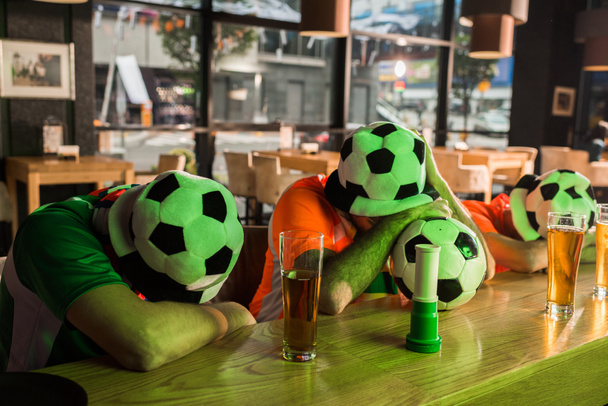 Fútbol ventiladores siesta en barra de madera contador
  - Foto, imagen