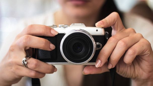 Giovane donna tiene una fotocamera compatta
 - Foto, immagini