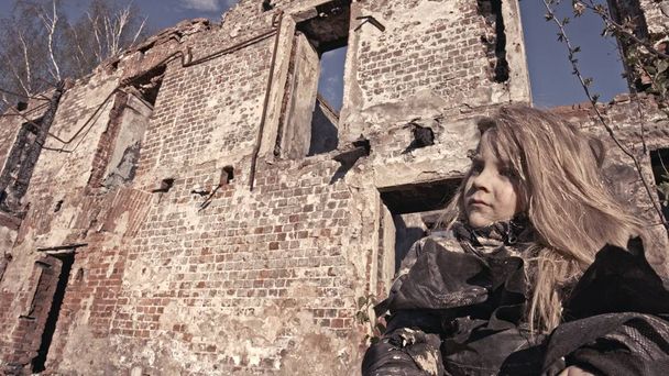portrait of dirty little homeless girl sitting against abandoned building - Fotoğraf, Görsel