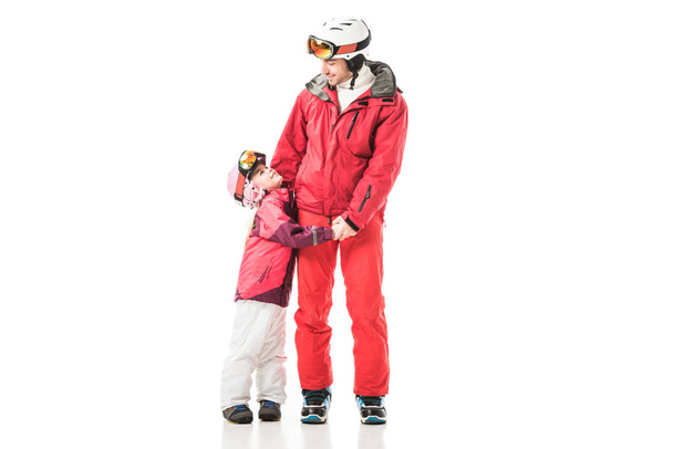 Father and daughter holding hands and standing in snowsuits isolated on white - Photo, Image
