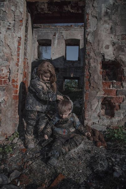 portrait of little dirty homeless kids with bear toy beside abandoned building - Photo, Image