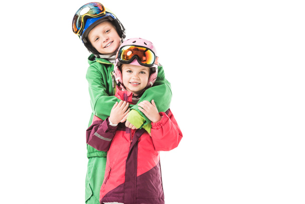 Sorella e fratello in piedi e abbracciati in tute da neve isolate su bianco
 - Foto, immagini