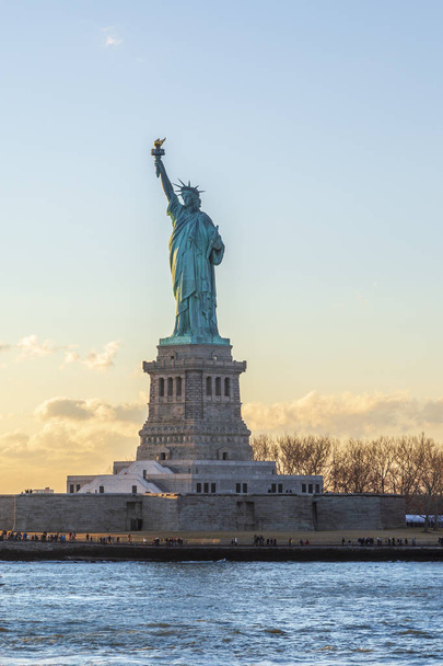ニューヨーク、ニューヨーク、アメリカ合衆国の日没時に垂直自由の女神 - 写真・画像