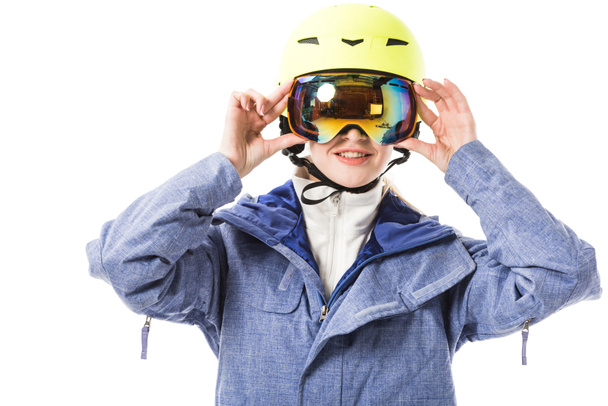jonge vrouw in blauwe ski jas, bril en helm glimlachend geïsoleerd op wit - Foto, afbeelding