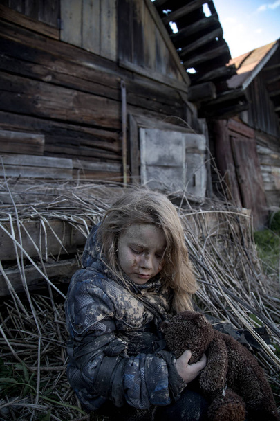 portrait of dirty little homeless girl with bear toy - Photo, image