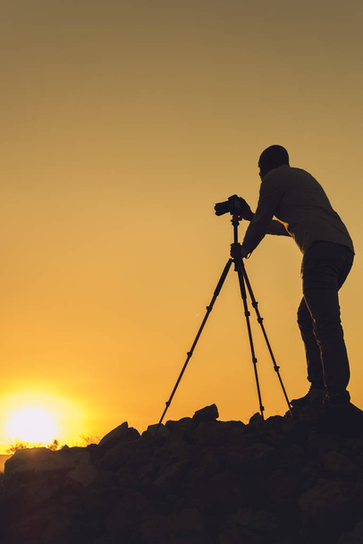 Silhouette of black photographer taking pictures at sunset. Image with copy space. - Photo, Image