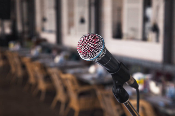 Impresión de cerca de un cantante de lápiz labial rojo en un micrófono de hierro plateado en las miradas en el escenario. Concepto de música en vivo en un restaurante o bar por la noche
 - Foto, Imagen