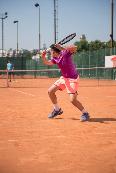 Young tennis player playing backhand - Fotoğraf, Görsel