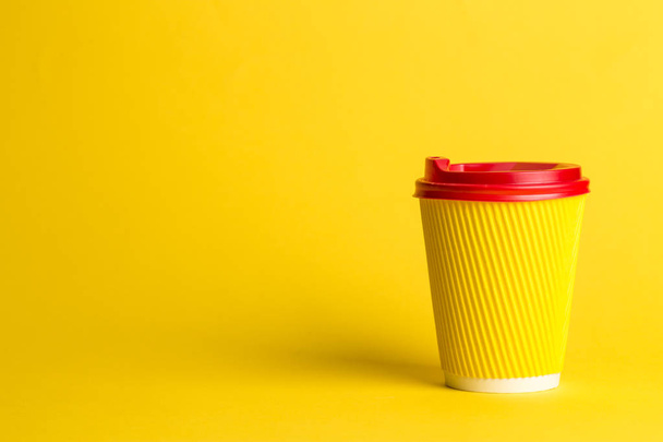 coffee to go in a disposable cup on a yellow background, place for text - Zdjęcie, obraz