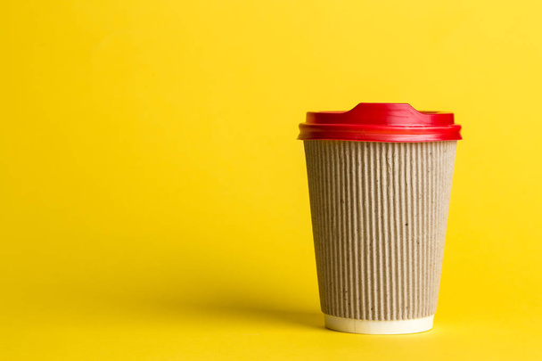 黄色の背景、テキストのための場所に使い捨てのカップでコーヒー - 写真・画像