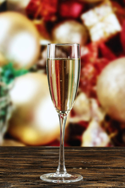 Champagner in Gläsern und in einer Flasche auf dem Hintergrund von Spielzeug am Weihnachtsbaum. Weihnachtlicher Hintergrund. Raum für Neues - Foto, Bild