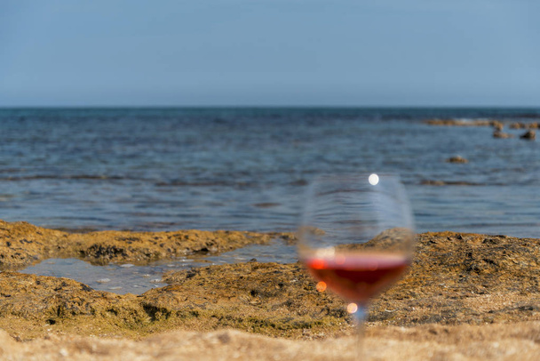 Copo de vinho tinto no litoral de Salento Itália
 - Foto, Imagem