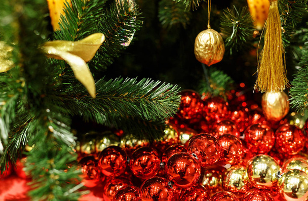 Χριστουγεννιάτικο δέντρο με κόκκινα παιχνίδια. Έννοια νέο έτος γιορτή φόντο. Φωτογραφία: closeup χριστουγεννιάτικο δέντρο διακοσμημένο με κόκκινο παιχνίδια - Φωτογραφία, εικόνα