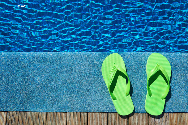 Zapatillas junto a una piscina
 - Foto, imagen