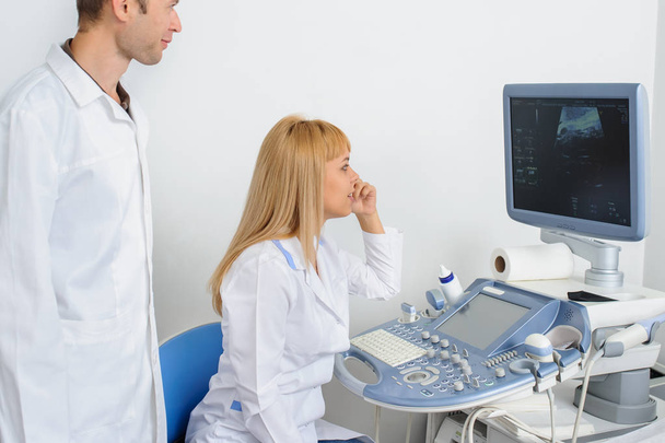 Двоє лікарів дивляться на ультразвукове ділення в медичному кабінеті
 - Фото, зображення