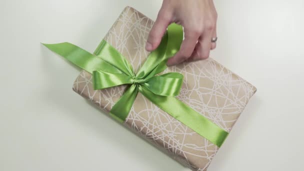 Κοντινό πλάνο γυναικεία χέρια δένοντας ένα τόξο στο παρόν πλαίσιο, αναδίπλωση τα δώρα σε όμορφο χαρτί, diy wraping, 4k Uhd - Πλάνα, βίντεο