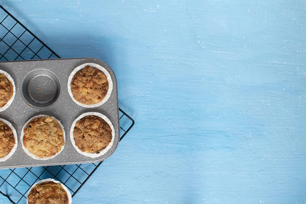 Domu do pieczenia koncepcja - świeże pieczone muffiny na chłodzenie rack, minimalny obraz, jasne niebieskie tło, tło, widok z góry, kopiować miejsca. - Zdjęcie, obraz